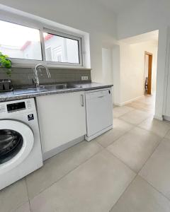 a kitchen with a washing machine and a sink at Casa Sagres T2 - 3 minutos a pé Praia da Mareta in Sagres