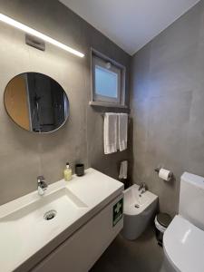 a bathroom with a sink and a toilet and a mirror at Casa Sagres T2 - 3 minutos a pé Praia da Mareta in Sagres