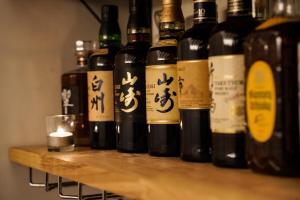 a row of bottles of wine sitting on a shelf at Country Inn Milky House in Niseko