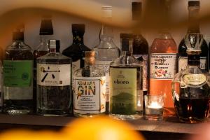 a row of bottles of alcohol on a shelf at Country Inn Milky House in Niseko