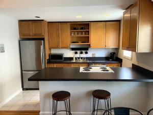 uma cozinha com armários de madeira e um balcão preto em Lovely Two Bedroom Condo in South Boston em Boston