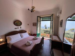 um quarto com uma cama e uma janela com vista em Papiro House em Taormina