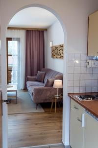 eine Küche und ein Wohnzimmer mit einem Sofa in der Unterkunft Geisbergerhof in Bad Birnbach