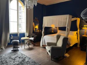 1 dormitorio con cama con dosel y silla en Les Chambres de Amelie B&B, en Bolonia