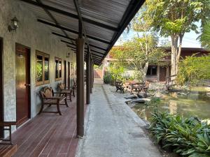 a porch of a building with a pond and benches at Chiang Khan Hill Resort in Chiang Khan