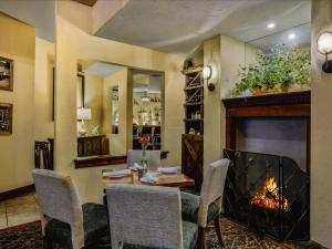 The Inn at Leola Village, a Historic Hotel of America في لانكستر: غرفة طعام بها موقد وطاولة وكراسي