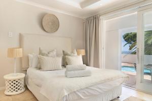 1 dormitorio con cama blanca y vistas al océano en Ingleside Luxury apartment by Totalstay en Ciudad del Cabo