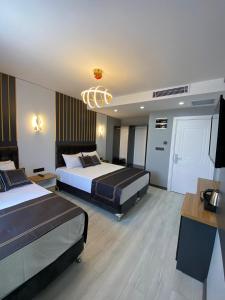 una camera d'albergo con due letti e un lampadario a braccio di Med Life Hotel İstanbul Airport a Arnavutköy