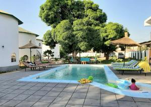 a child playing in a swimming pool with a toy at Afro Garden in Sere Kunda