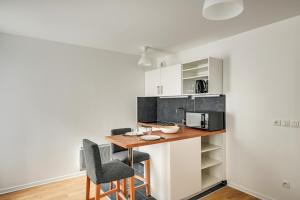 a kitchen with a table and two chairs at La Vallée-Chatenay Malabry in Châtenay-Malabry +6 photos