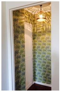 a hallway with a chandelier in a room with a wall at Cosy apartment PARIS XIIème in Paris