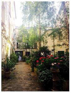 an alley with flowers and plants in a building at Cosy apartment PARIS XIIème in Paris