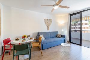 - un salon avec un canapé bleu et une table dans l'établissement Summerland FREE WIFI, à Los Cristianos