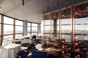 een restaurant met tafels en stoelen en een grote glazen wand bij MYRIAD by SANA Hotels in Lissabon
