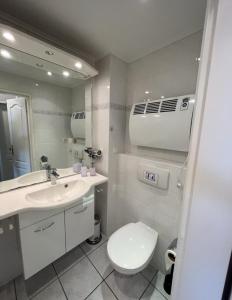 bagno con servizi igienici, lavandino e specchio di Ferienwohnung Meeresblick Cordy a Sankt Peter-Ording
