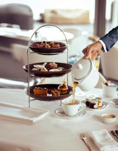 une personne versant du café dans une tasse sur une table dans l'établissement MYRIAD by SANA Hotels, à Lisbonne