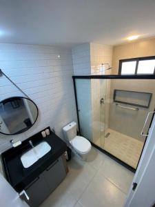 a bathroom with a toilet and a sink and a shower at Flat Premium No Centro in Porto De Galinhas