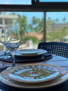a table with plates and glasses on a table at Flat Premium No Centro in Porto De Galinhas