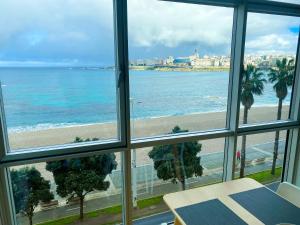 una finestra con vista sulla spiaggia di Apartamento acogedor con vistas al mar. a La Coruña