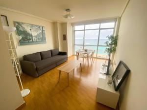 un soggiorno con divano e tavolo di Apartamento acogedor con vistas al mar. a La Coruña
