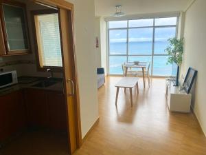 a kitchen and dining room with a table and a view of the ocean at Apartamento acogedor con vistas al mar. in A Coruña
