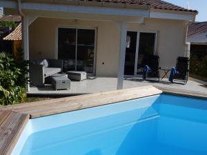 a blue swimming pool in front of a house at La Maison du Sommeil in Loubès-Bernac