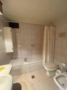 y baño con bañera, aseo y lavamanos. en Departamento de Categoría Av. España en Mendoza