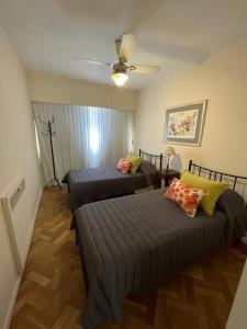 1 dormitorio con 2 camas y ventilador de techo en Departamento de Categoría Av. España en Mendoza