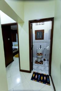 a bathroom with a toilet in a room with a mirror at The Mbuya Residence in Kampala