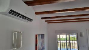uma cozinha com paredes brancas e vigas de madeira em HELLO OLIVA BEACH Bungalow Alto em Oliva