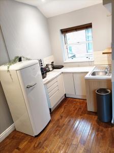 a small kitchen with a refrigerator and a sink at Self-contained Studio in Central London property Unit 4 in London