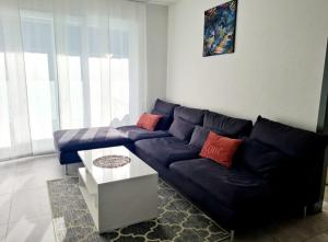sala de estar con sofá azul y mesa en GaLa Appartamento, en Bellinzona