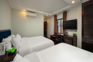 ein Hotelzimmer mit 2 Betten und einem Flachbild-TV in der Unterkunft Cristina Center Hotel & Spa in Hanoi