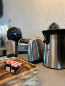 a tea kettle and a basket of bread on a counter at Appartement cosy avec vue mer in Stella-Plage