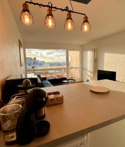 a kitchen with a counter top with lights on it at Appartement cosy avec vue mer in Stella-Plage
