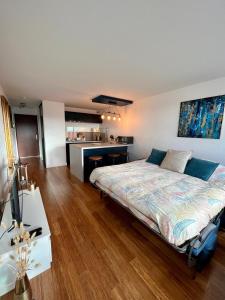 a bedroom with a large bed and a kitchen at Appartement cosy avec vue mer in Stella-Plage
