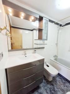uma casa de banho com um lavatório, um WC e um espelho. em Apartamento San Marcos by SanSe Holidays em San Sebastián
