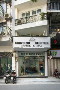 ein Geschäft vor einem Gebäude mit einem Motorrad, das vorne geparkt ist in der Unterkunft Cristina Center Hotel & Spa in Hanoi