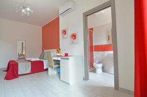 1 dormitorio con cama, escritorio y baño en Le Falesie di Castelluzzo en Castelluzzo