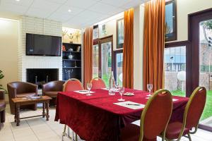 a dining room with a red table and chairs at Hôtel des Arcades de Cachan - Grand Paris Sud in Cachan