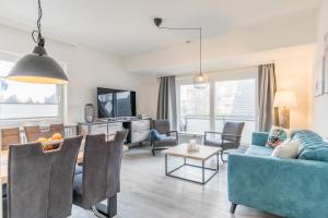 a living room with a blue couch and a table at "Haus Deichlodge" deichlodge lodge fünf in Büsum