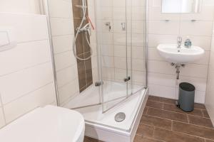 a bathroom with a shower and a toilet and a sink at "Haus Deichlodge" deichlodge lodge fünf in Büsum +19 photos