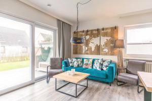 a living room with a blue couch and chairs at "Haus Deichlodge" deichlodge, lodge eins in Büsum