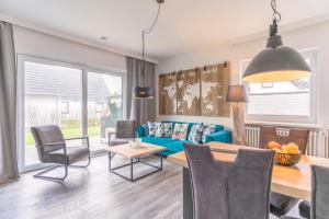 a living room with a blue couch and a table at "Haus Deichlodge" deichlodge, lodge eins in Büsum