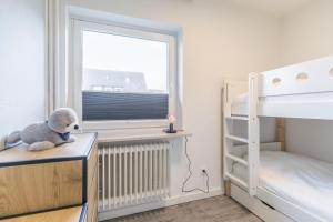 a bedroom with a bunk bed and a teddy bear on a desk at "Haus Deichlodge" deichlodge, lodge eins in Büsum