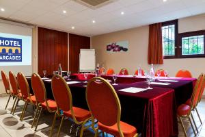 una sala de conferencias con una mesa larga y sillas en Hôtel des Arcades de Cachan - Grand Paris Sud, en Cachan