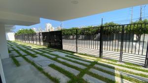 a fence with grass on the side of a sidewalk at Suite Nueva en Salinas - Chipipe, en conjunto privado in Salinas