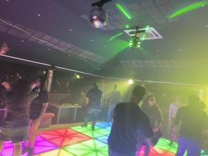 ポンディシェリにあるNT Hotels and Resorts Akridhaのネオンライトの舞う部屋で踊る集団