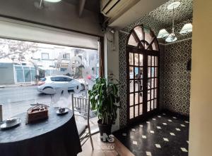 サンフアンにあるHotel Nuevo Suizoのテーブルと窓(外に車あり)が備わる客室です。