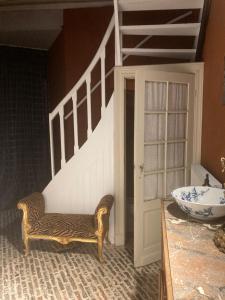 a room with a staircase and a chair and a sink at Canal Central in Bruges